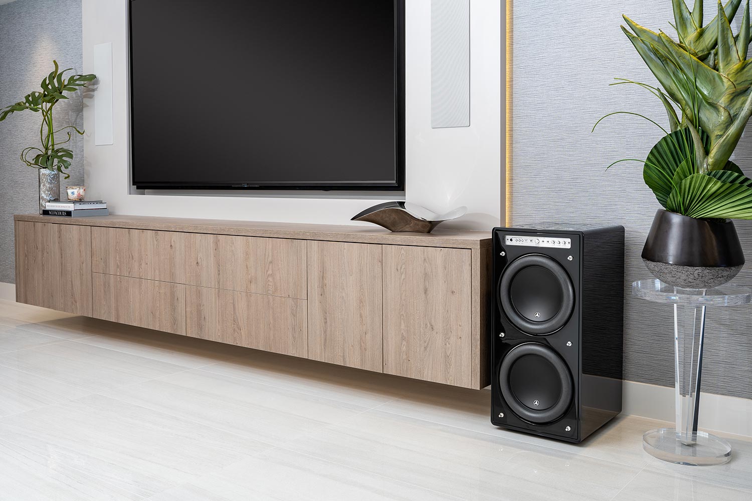 Wall-mounted TV with a floating media console and dual subwoofer speaker