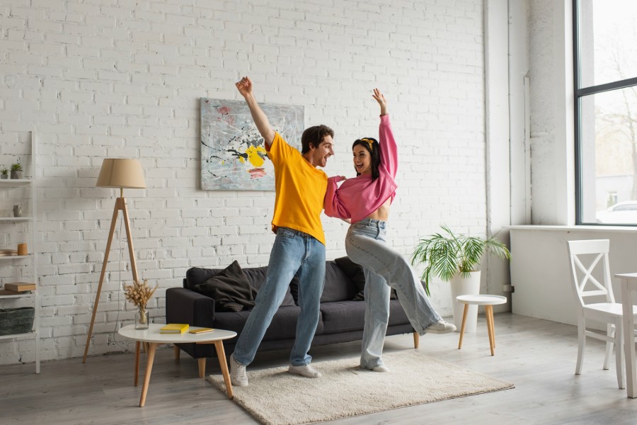  A happy couple dancing together in their living room