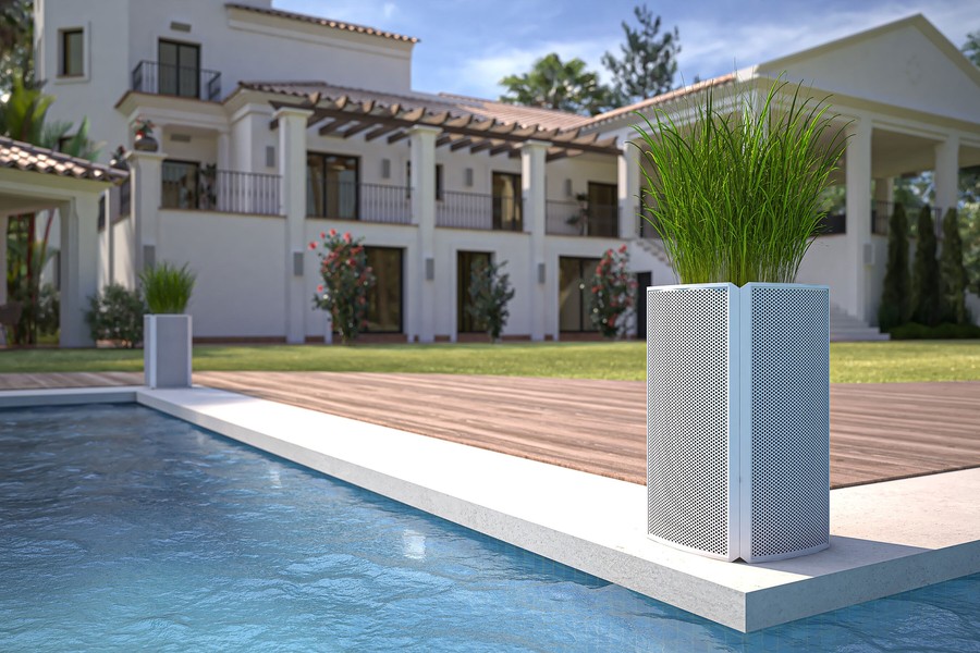 Coastal Source Razor speakers installed around planters by a home’s pool.