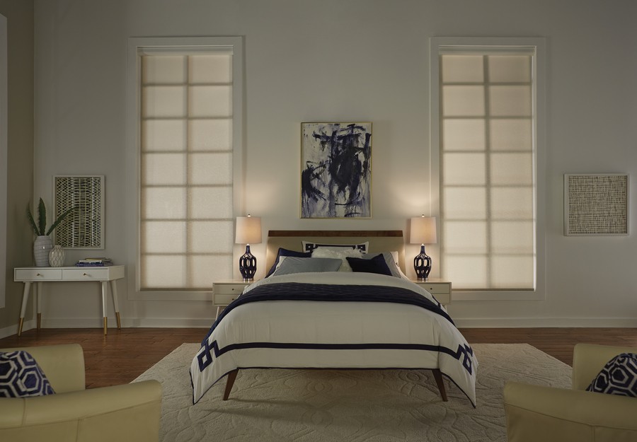 A bedroom with Lutron motorized shades lowered on the windows.