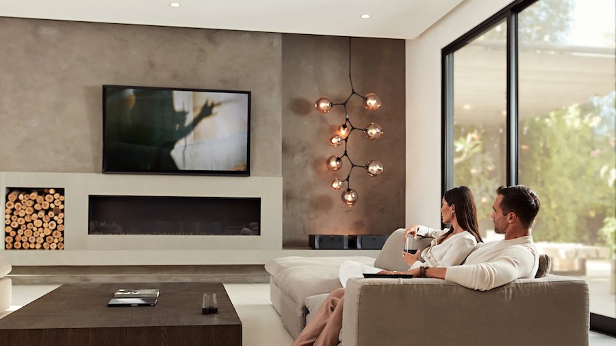A couple enjoys music from a high-end audio system while sitting on their couch in their Scottsdale home.